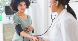 Doctor taking woman's pulse